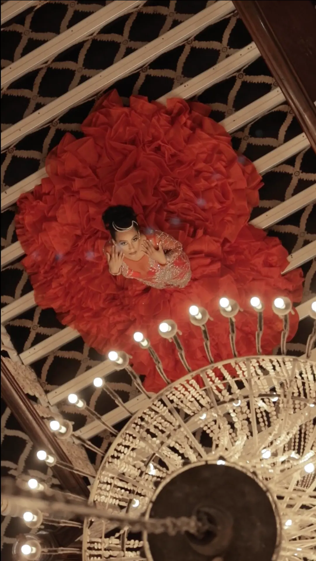 Overhead shot of a red couture gown under a chandelier