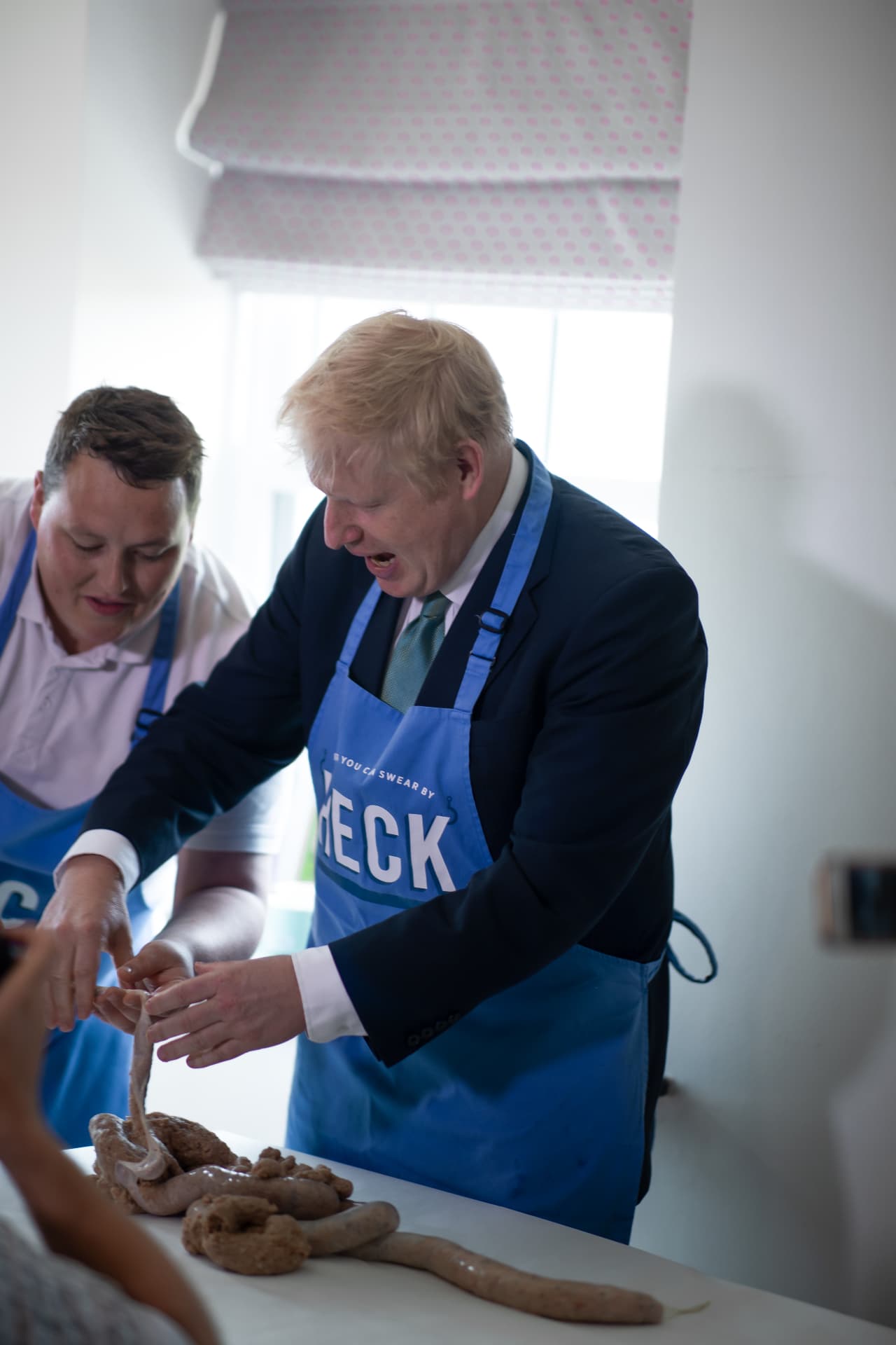 Boris Johnson making sausages in a HECK apron on a brand shoot